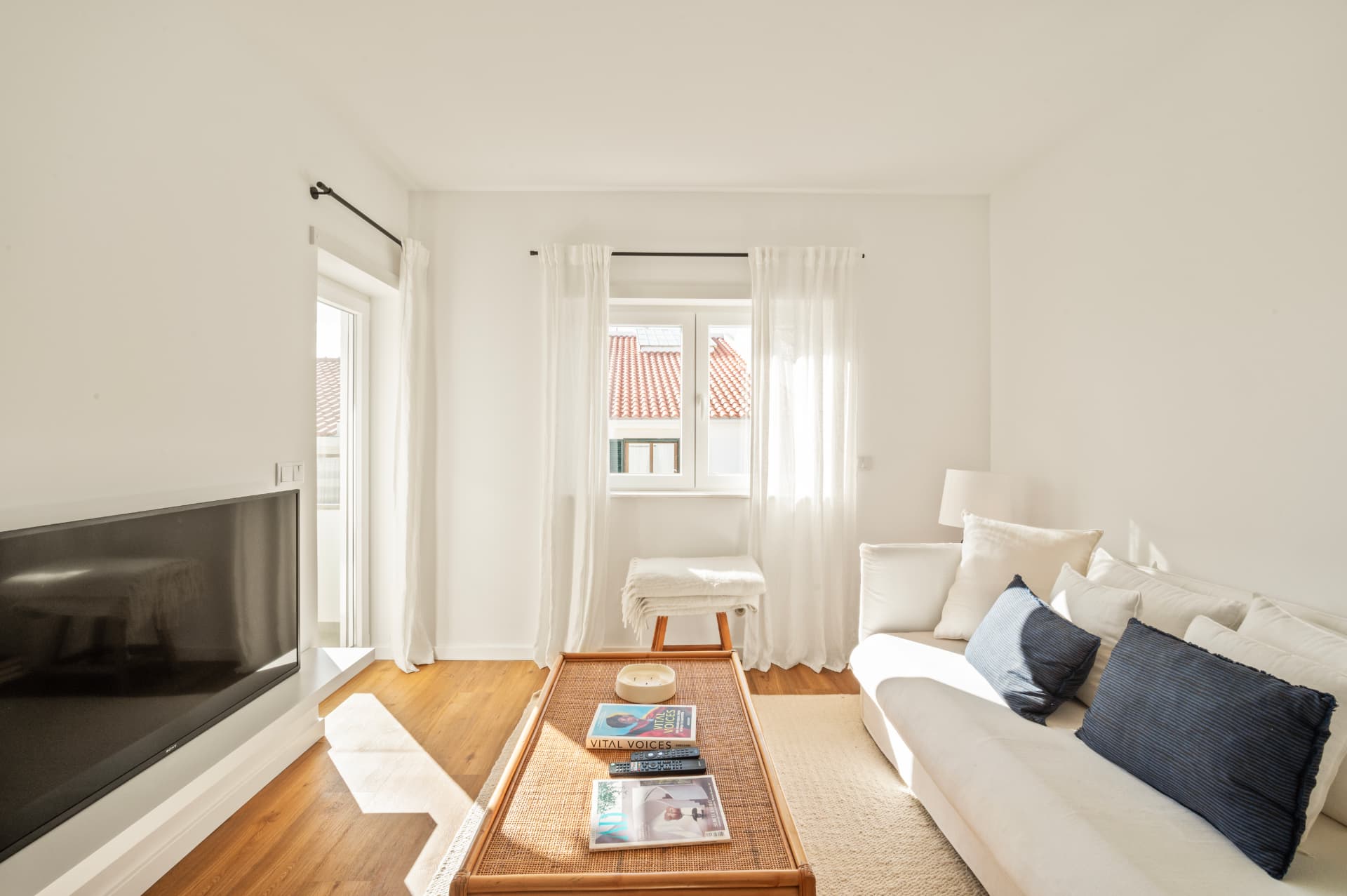 Living room with a white sofa, TV and rattan coffee table